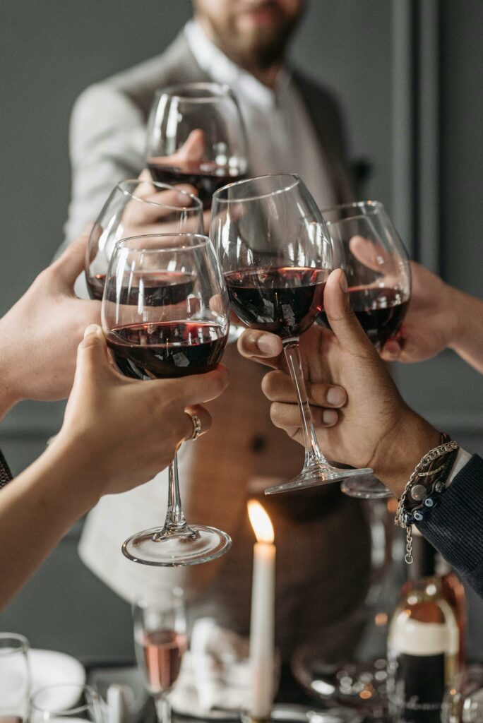 Un verre de vin rouge à la main un groupe de consommateurs trinquent