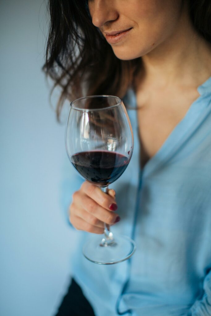 Femme souriante avec un verre de vin rouge à la main