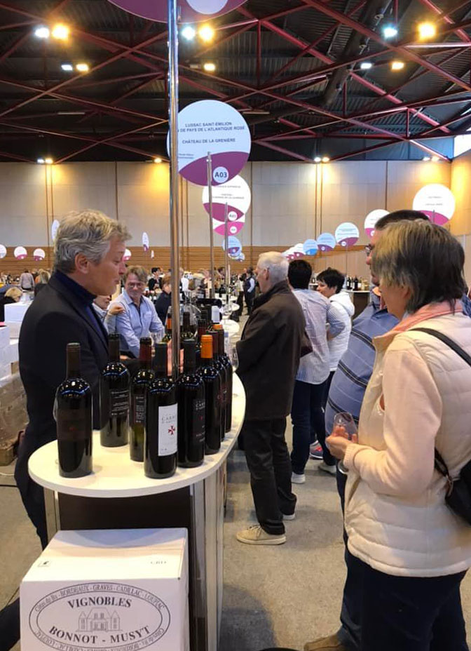 Des particuliers discutent avec un vigneron sur un salon grand public