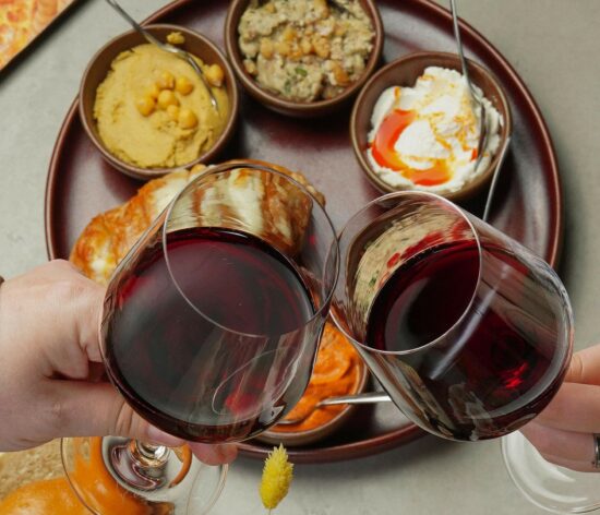 deux verres de vin rouge avec des tapas et autres apéritifs